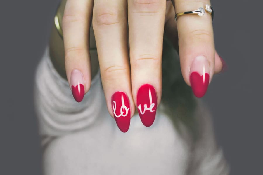 Red nails with hand-painted lettering