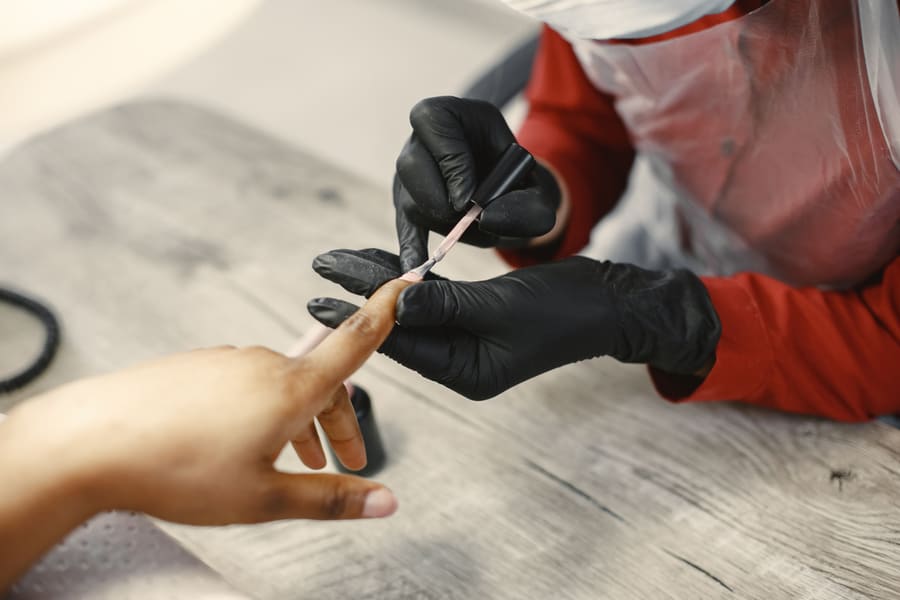 A technician shaping a client's nails
